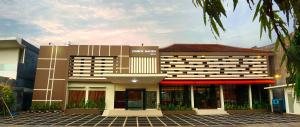 a hotel building with a red awning in front of it at Lombok Mayura Hotel in Tjakranegara