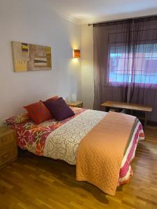 a bedroom with a bed and a table and a window at GranVia Fira Apartment in Hospitalet de Llobregat