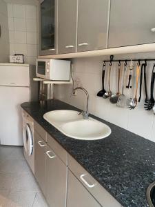 cocina con fregadero y microondas en GranVia Fira Apartment, en Hospitalet de Llobregat