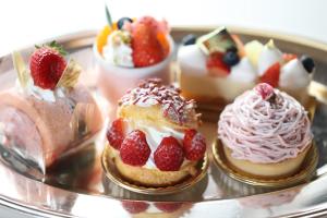 a group of desserts on a plate with strawberries and whipped cream at Kamakura Park Hotel in Kamakura