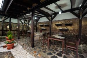 a restaurant with tables and chairs and a brick wall at Hotel Theatre in Bitola