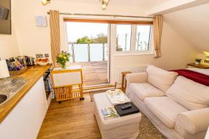 pequeña sala de estar con sofá y cocina en Sea View Holiday Flat - Covehurst Bay, en Hastings