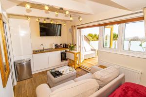 a living room with a couch and a kitchen at Sea View Holiday Flat - Covehurst Bay in Hastings