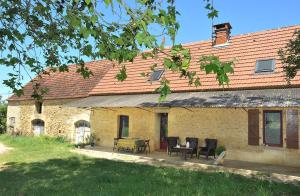 a brick house with a table and chairs in front of it at Chambres d'hôtes Gourdon in Gourdon