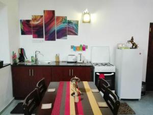 a kitchen with a table and a refrigerator at Best Inn Villa Mirissa in Mirissa