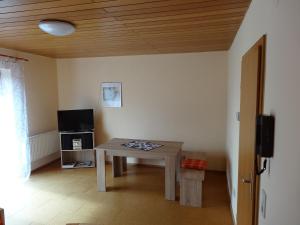 a living room with a table and a television at Lembergblick in Wellendingen