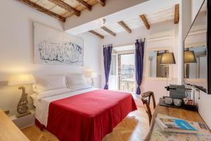 um quarto com uma cama com um cobertor vermelho em The Bluehostel em Roma