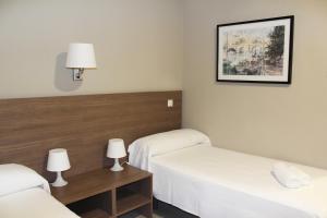 Łóżko lub łóżka w pokoju w obiekcie Hotel La Parada