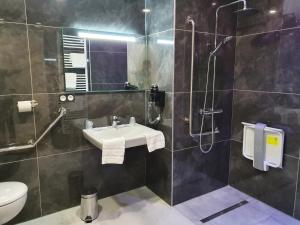 a bathroom with a sink and a shower and a toilet at Berg'hotel in Socx