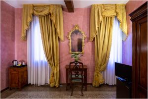 a room with yellow curtains and a table and a mirror at Hotel Marconi in Venice