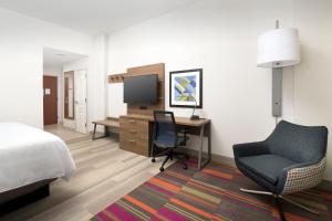 ein Hotelzimmer mit einem Bett, einem Schreibtisch und einem Stuhl in der Unterkunft Holiday Inn Express Jacksonville Beach by IHG in Jacksonville Beach + 34 Fotos