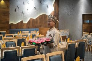a man is holding a tray of cupcakes at HOTEL SILVERA GRAND in Ahmedabad