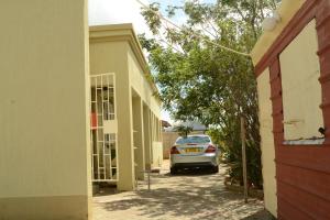 a car parked in a driveway between two buildings at Sharon Rose Guesthouse in Windhoek