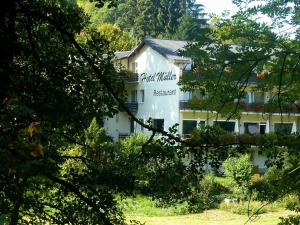 a white building with a sign on the side of it at Landhotel Krolik in Daun