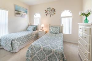 two beds in a bedroom with two windows at Three-Bedroom Pool Home Davenport in Davenport