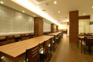 an empty classroom with wooden tables and chairs at AB Hotel Nagoya Sakae in Nagoya