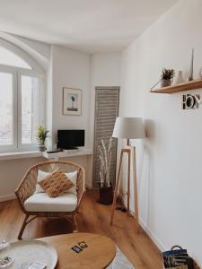 a living room with a chair and a table at Le Carnet de Sète et sa vue sur le canal in Sète