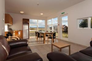 ein Wohnzimmer mit einem Tisch und Stühlen sowie eine Küche in der Unterkunft Guesthouse Eldhestar in Hveragerði