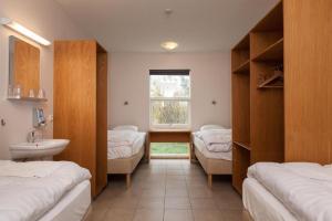 um quarto com 3 camas, um lavatório e uma janela em Guesthouse Eldhestar em Hveragerði