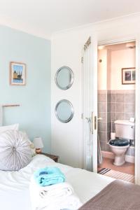 a bedroom with a bed and a bathroom with a toilet at CreekSide Bed and Breakfast Faversham in Faversham