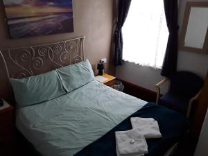 a bedroom with a bed with two towels on it at Hotel Royale in Blackpool