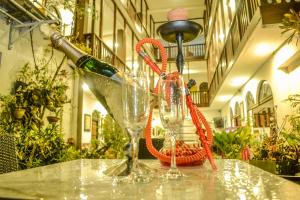 a table with two glasses and a bottle of wine at Hotel Sunray in Kandy