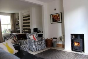 uma sala de estar com duas cadeiras e uma lareira em Guillemot em Beaumaris