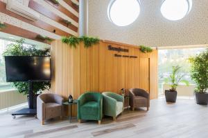 a waiting room with chairs and a flat screen tv at IBB Hotel in Minsk