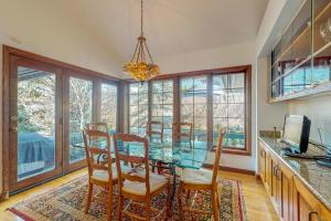 a dining room with a glass table and chairs at Wayne Creek Residence in Avon