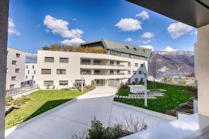 an apartment building with a view of the mountains at LE LYRIQUE in Annecy