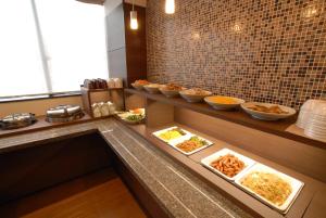 AB Hotel Isesaki في Isesaki: طابور بوفيه مع اطباق طعام في مطعم