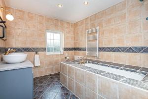 a bathroom with a tub and a sink at Felin Traeth Cottage in Rhosneigr +40 photos
