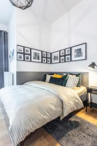 - une chambre avec un lit et des photos sur le mur dans l'établissement A Prague Apartments - Lesser Town, à Prague