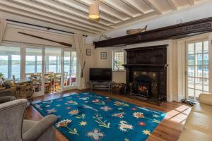 a living room with a fireplace and a blue rug at The Moorings in Cemaes Bay