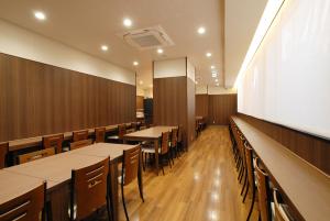 a dining room with tables and chairs and a whiteboard at AB Hotel Mikawa Toyota in Toyota