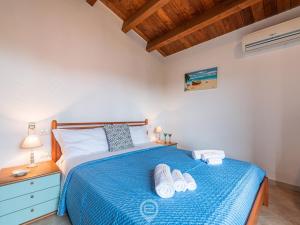 um quarto com uma cama azul com duas toalhas em La Mora - Apartment Near the Sea em Castiadas