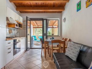 uma cozinha e sala de jantar com uma mesa e um sofá em La Mora - Apartment Near the Sea em Castiadas