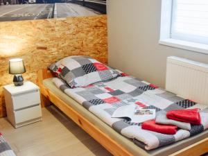 プウォツクにあるBielik - Pokoje Gościnneのベッド1台(チェック入りの毛布、赤い枕付)