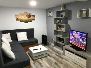 a living room with a couch and a flat screen tv at Casita tranquila in Talavera de la Reina