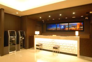 a lobby with a reception desk with two chairs and a tv at AB Hotel Gifu in Gifu