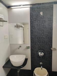 a bathroom with a white sink and a mirror at Hotel Avon International in Aurangabad