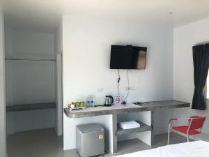 a room with a desk and a tv on a wall at SiRi Resort in Maha Sarakham