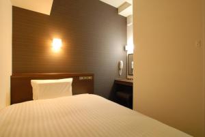 Pokój hotelowy z łóżkiem i biurkiem w obiekcie AB Hotel Iwata w mieście Iwata