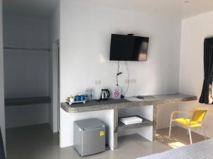 a room with a desk with a tv and a yellow chair at SiRi Resort in Maha Sarakham