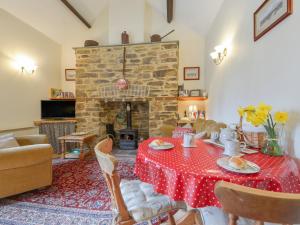 a living room with a table and a fireplace at Miners Dry in Gunnislake