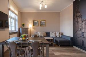 a living room with a table and a couch at Happy Stay Mariacka Apartment II in Gdańsk