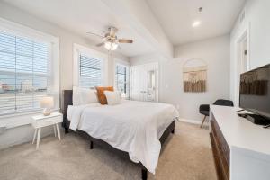 a white bedroom with a bed and a flat screen tv at Stunning Waco Downtown Apartments in Waco
