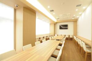 an empty lecture room with wooden tables and chairs at AB Hotel Omihachiman in Omihachiman