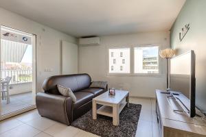 Una sala de estar con un sofá de cuero y una mesa. en Appart L'avant Scene Tresums, en Annecy