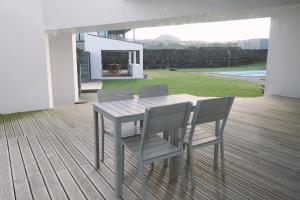 a wooden table and chairs on a wooden deck at Sao Vicente Lodge - Atlantic Retreat in São Vicente Ferreira